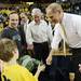Michigan head coach John Beilein, left, smiles as a young fan shows him his green and white shirt as Michigan  Lieutenant Governor Brian Calley and Governor Rick Snyder stand by after Michigan beat Michigan State 58-57 at Crisler Center on Sunday, March 3, 2013. Melanie Maxwell I AnnArbor.com